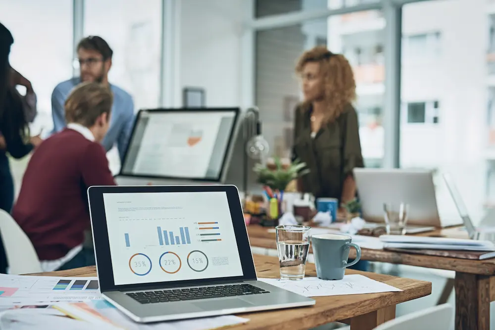 Primo piano di un computer portatile che mostra l'interfaccia della dashboard e della chat con intelligenza artificiale del software MetricMate.