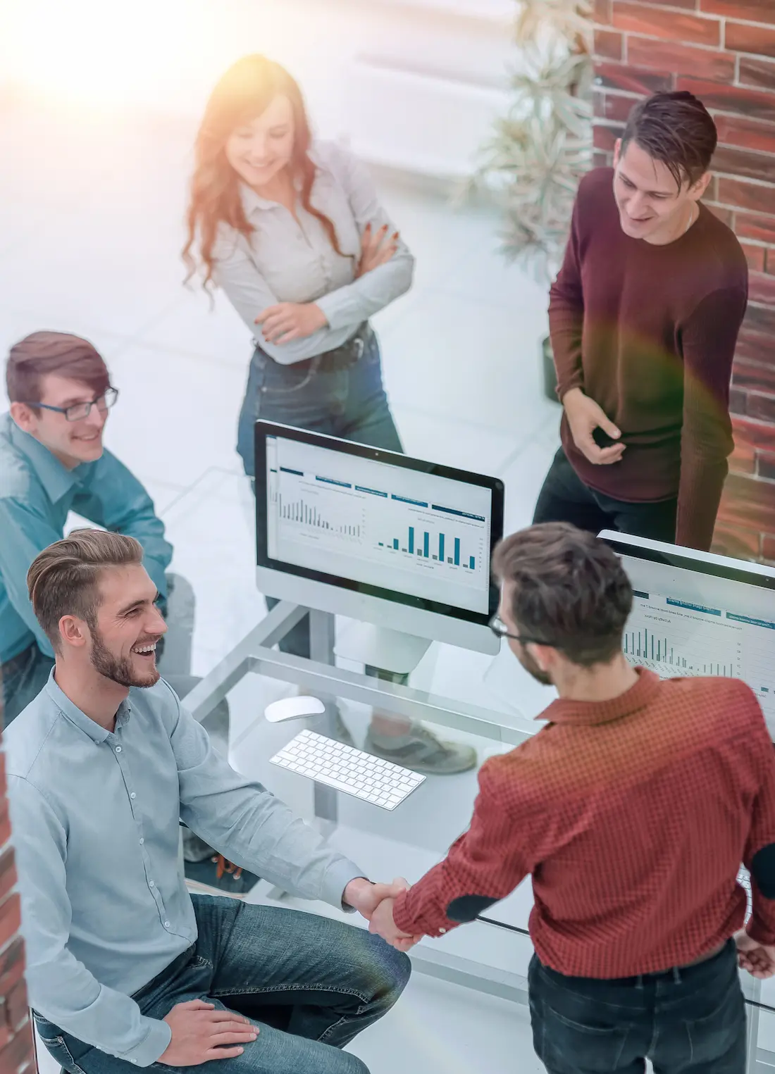 Il team aziendale riunito davanti agli schermi dell'ufficio mentre lavora all'analisi dati sulla piattaforma MetricMate.
