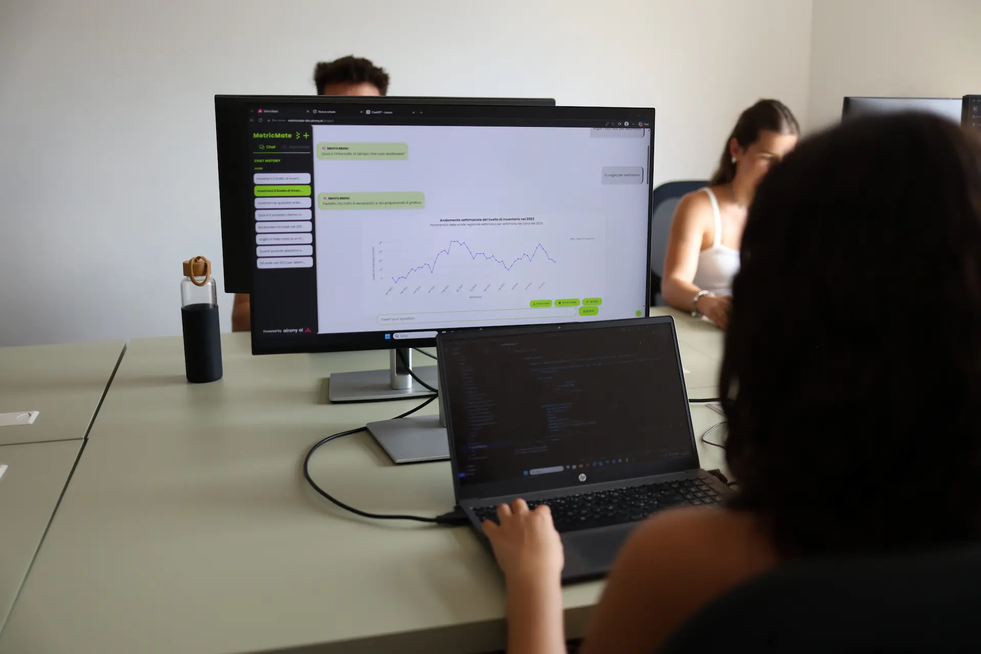 Schermo di un computer da ufficio che mostra la chat di MetricMate con un grafico lineare di andamento aziendale interrogato in linguaggio naturale.