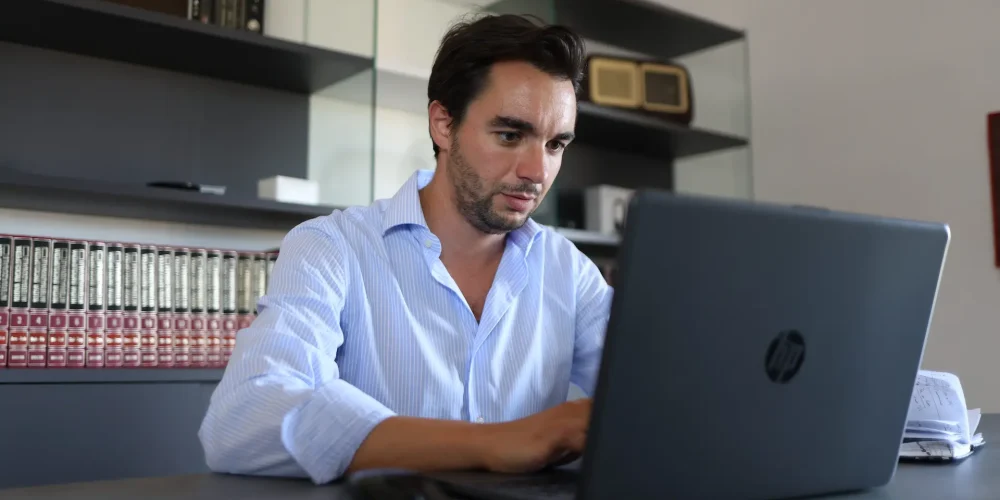Manager di una PMI italiana che utilizza il software di Business Intelligence conversazionale MetricMate su un computer portatile in ufficio.